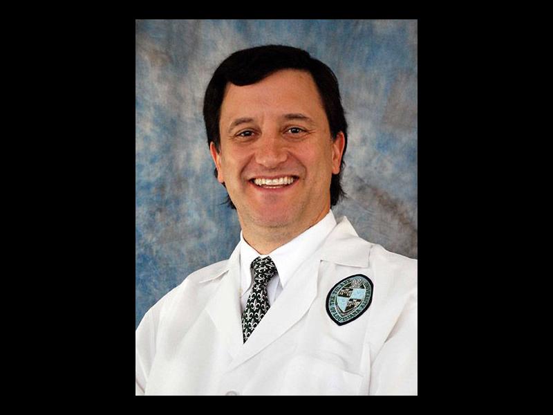 David MUshatt, wearing doctor's white coat, smiling