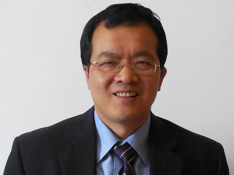Shusheng Wang, headshot, smiling, wearing a suit, wearing glasses
